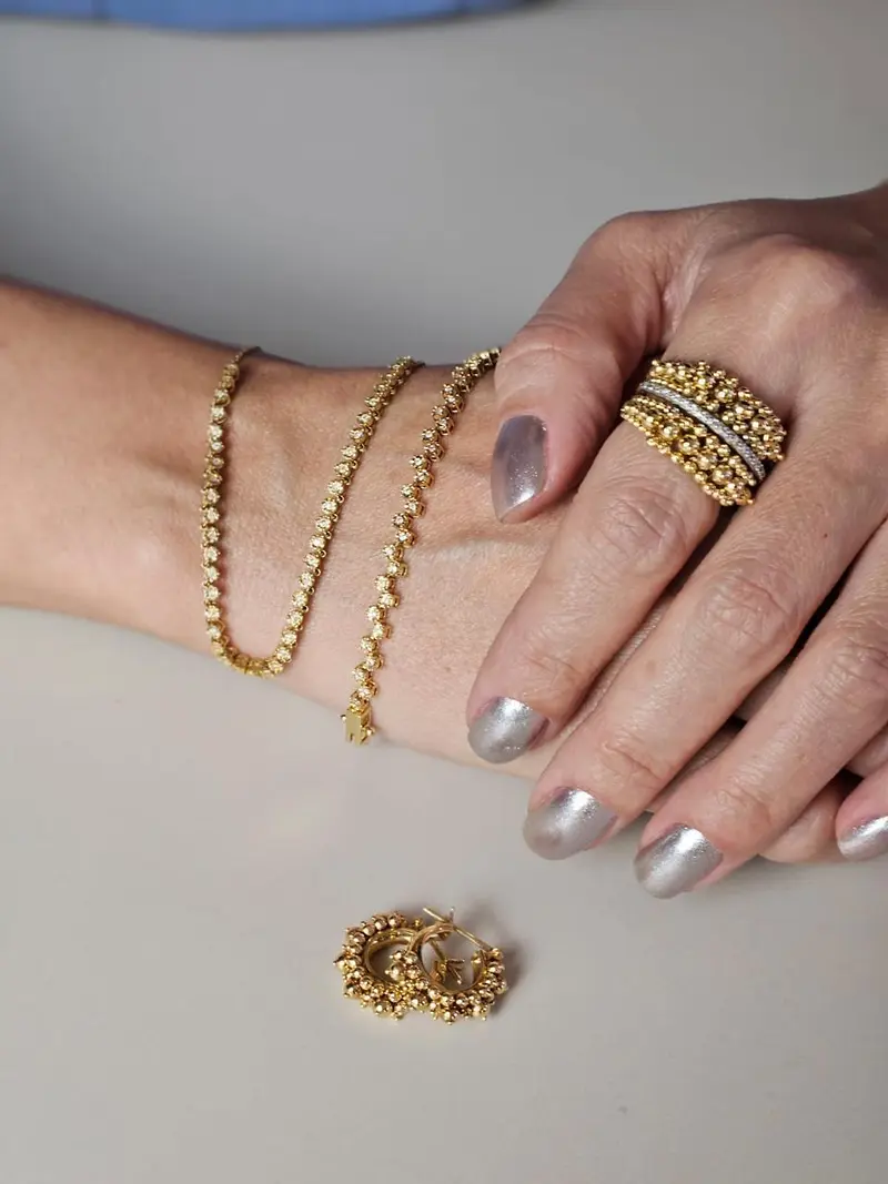 Mãos com joias em Ouro 18k, incluindo anel e colares dourados